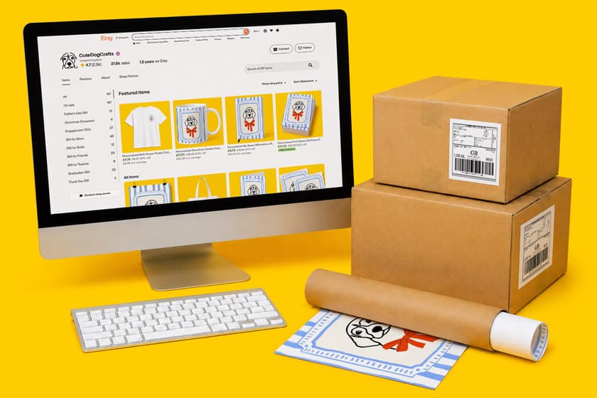 A computer displays an online shop; shipping boxes and products are arranged nearby.
