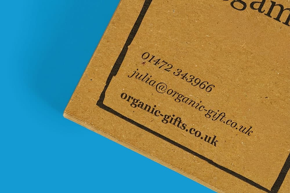 Corner of a brown card showing contact details on a blue background.