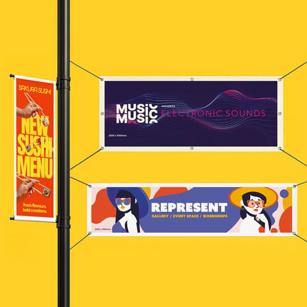 Three colorful event and menu banners hang against a bright yellow wall and black pole.