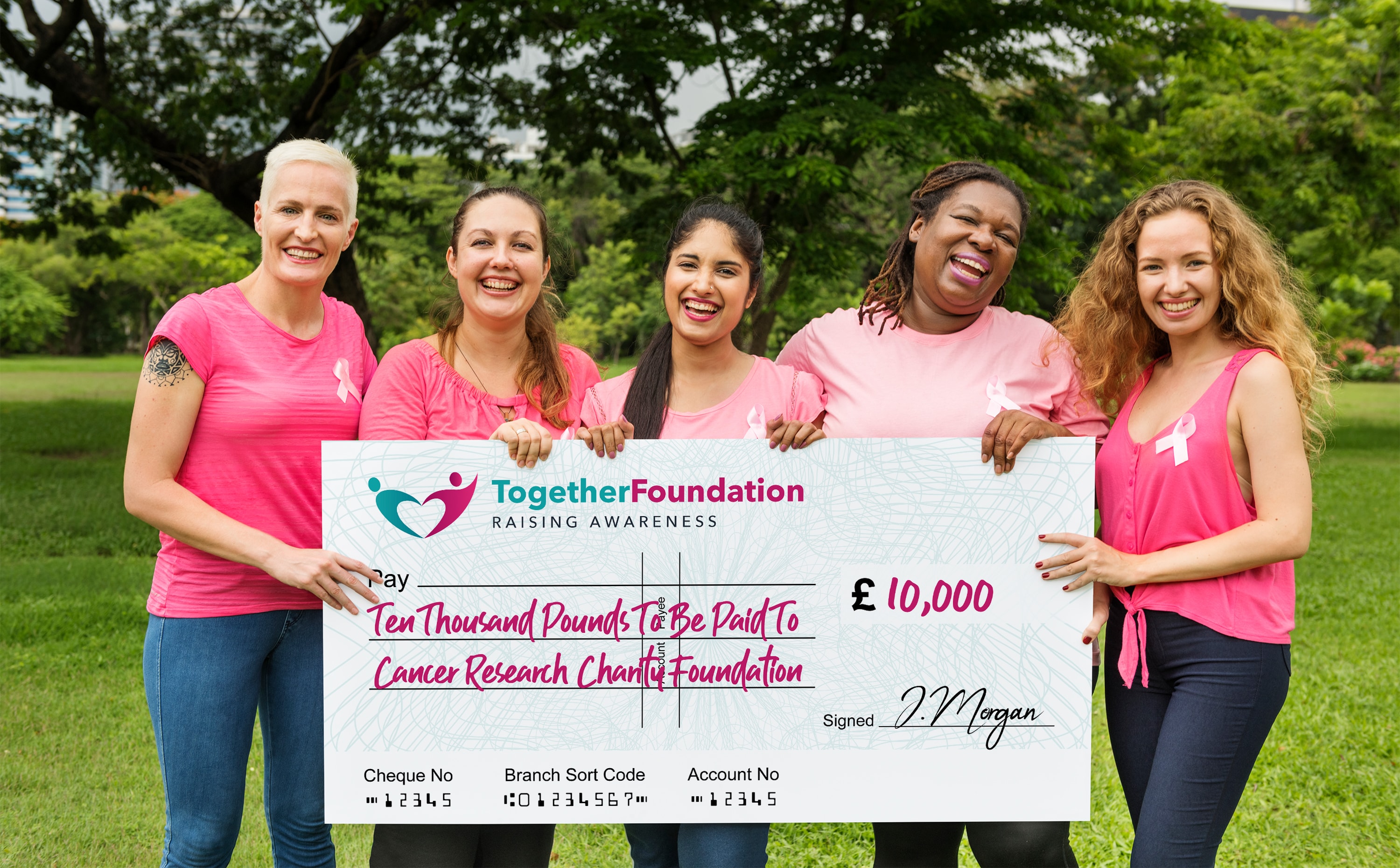 Five women holding a large charity cheque for £10,000 to a cancer research foundation.