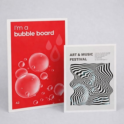 Two posters: one red with bubbles, one with black-white optical art, standing side by side.