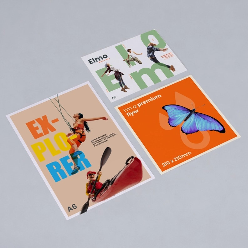 Three colorful A6 flyers on a gray surface, featuring bold text and graphic images.