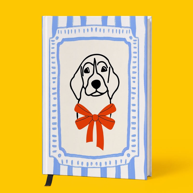 Journal with a beagle illustration and red bow on a blue and white striped cover, yellow background.