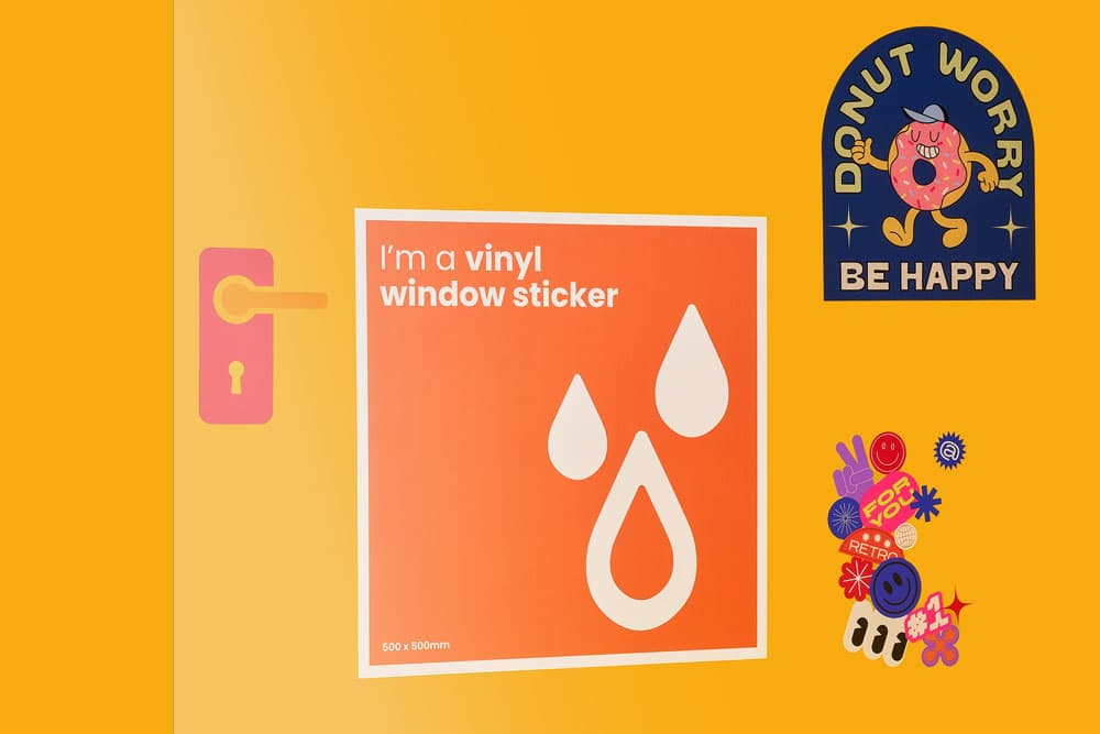 Orange wall with vinyl window sticker, "Donut Worry Be Happy" sticker, and colorful small stickers.