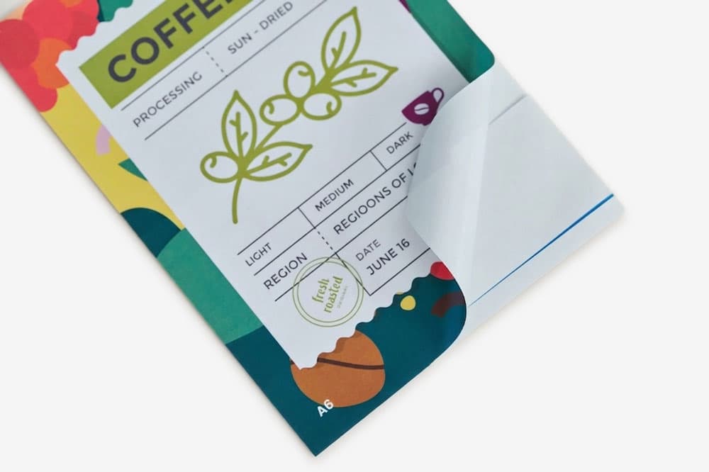 A close-up of a coffee label with a sticker partially peeled off the bottom right corner.