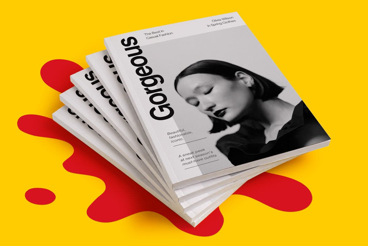 Stack of fashion magazines with a black-and-white cover photo of a woman, on a yellow background.