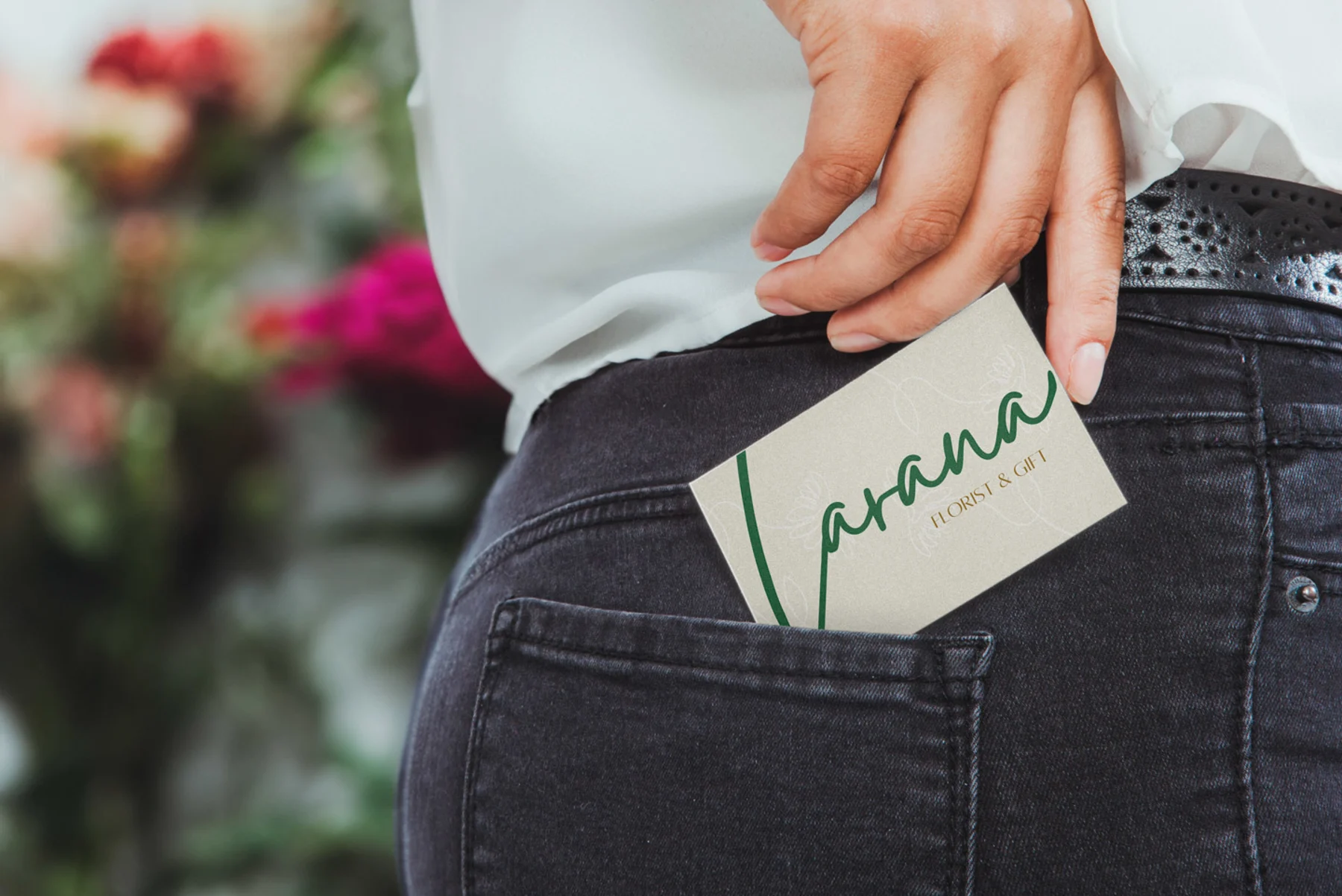 A woman with a business card tucked into her jean pocket