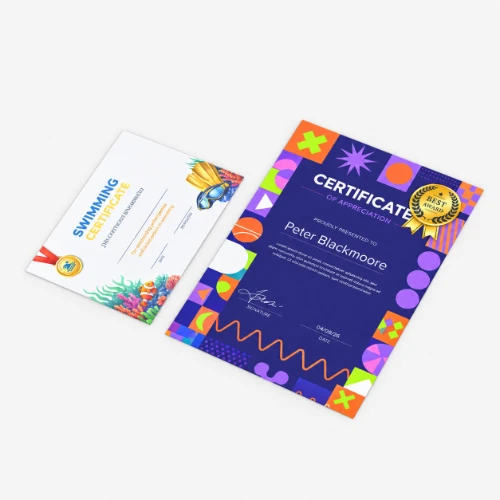 Two certificates laying on a grey surface, one for swimming and one for appreciation.