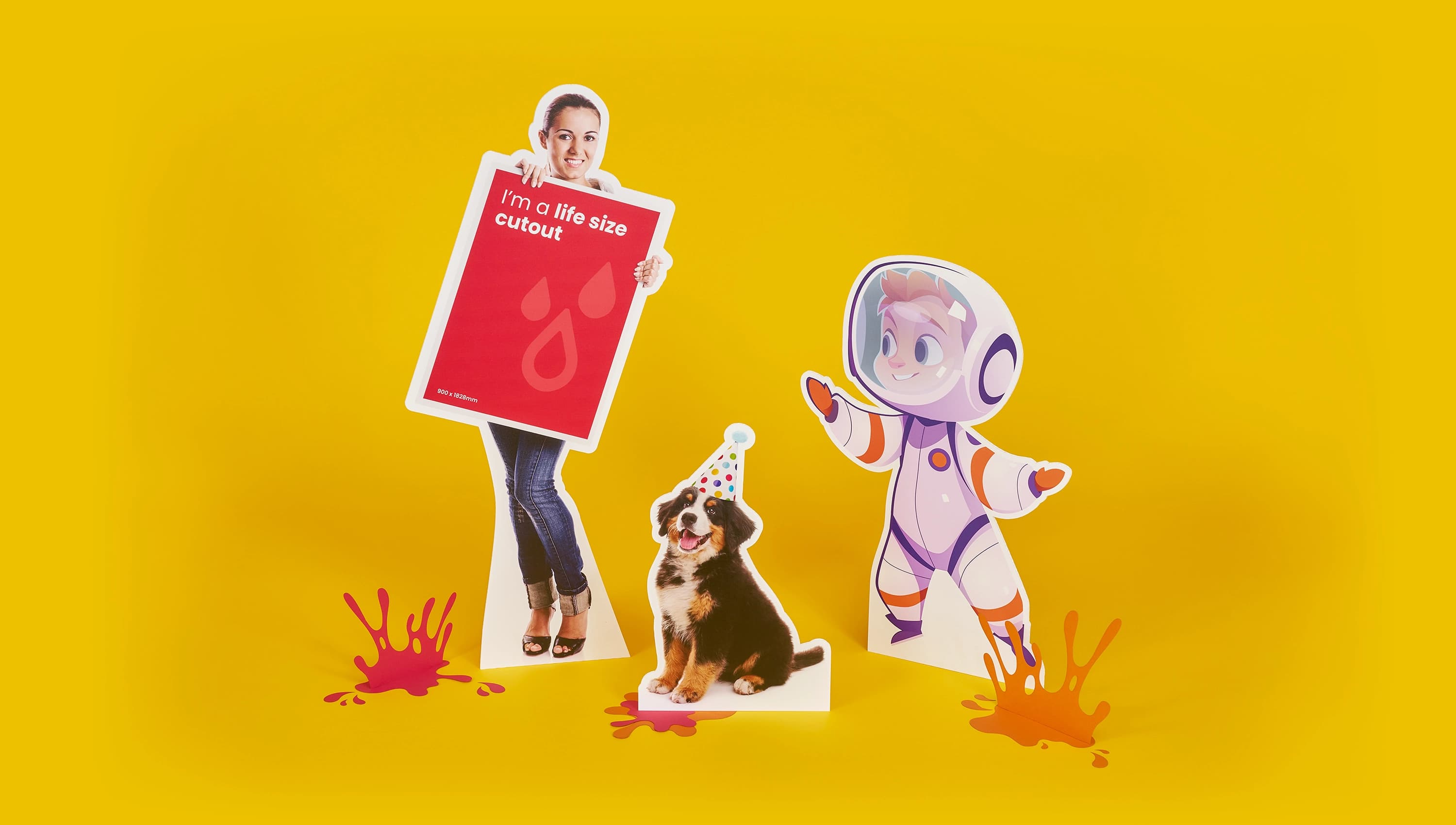 Cardboard cutouts of a person, a dog, and an astronaut on a yellow background.