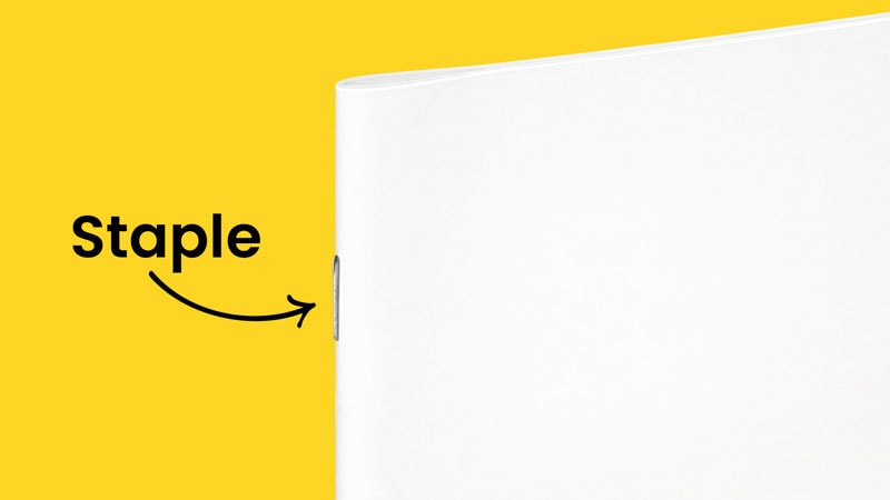 A booklet stapled at the edge, with the word "Staple" and an arrow pointing.