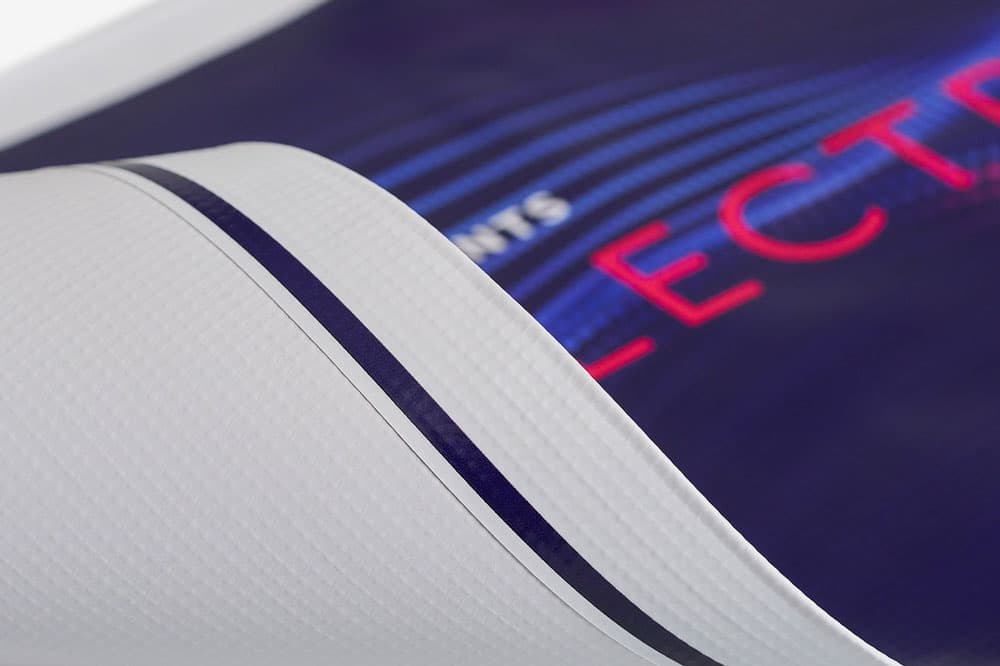 A close-up of a rolled-up printed banner with textured white backing and a colored design.