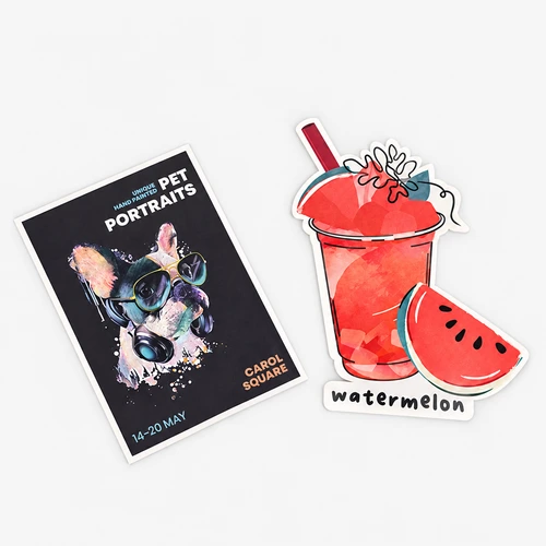 A flyer for pet portraits and a watermelon drink sticker are placed on a light gray surface.