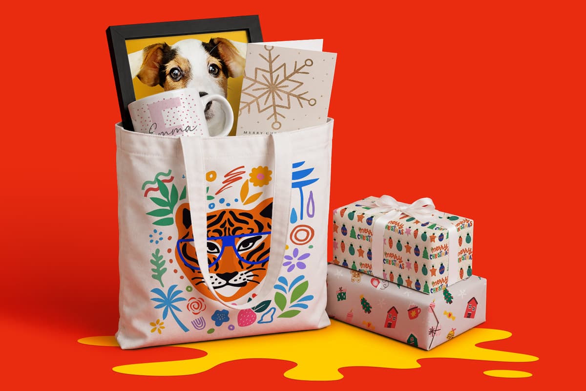 Tote bag with tiger design holds a mug, card, and dog photo, next to two wrapped gifts.
