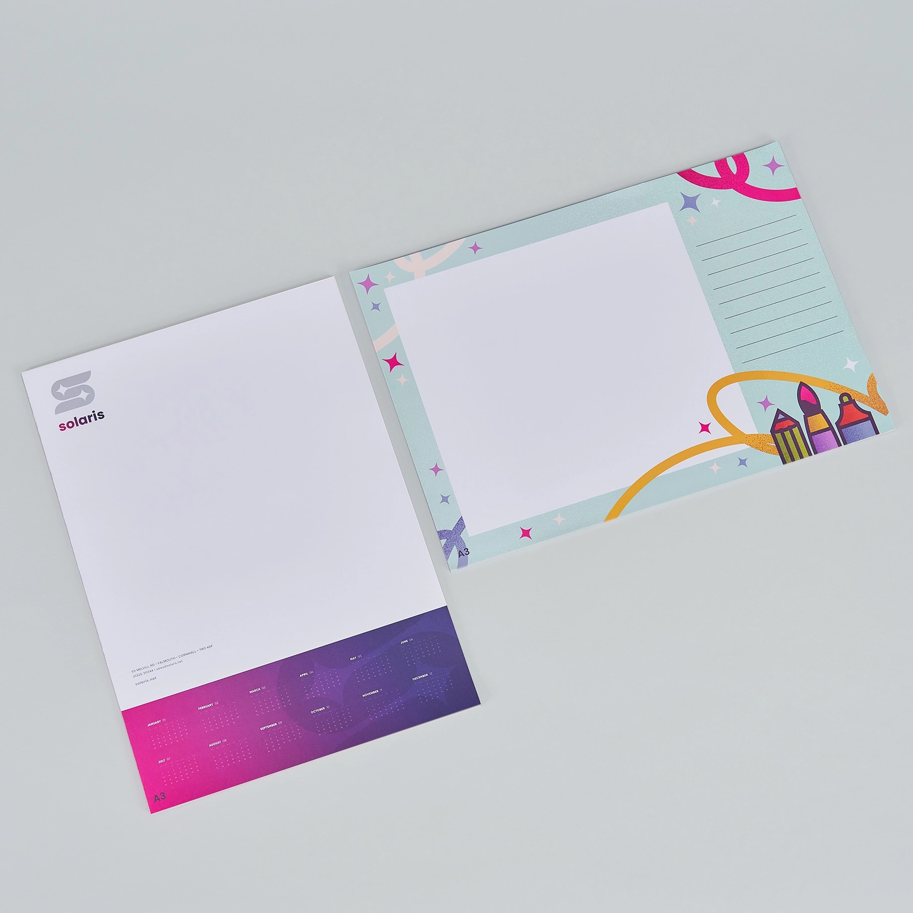 Two desk pads, one with a business design and one with a colorful, playful border.