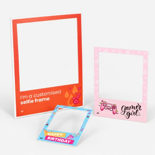 Three different themed cardboard photo booth frames.