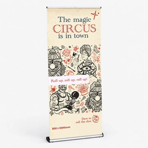 A circus-themed banner stand with illustrations and text promoting "The magic CIRCUS is in town.