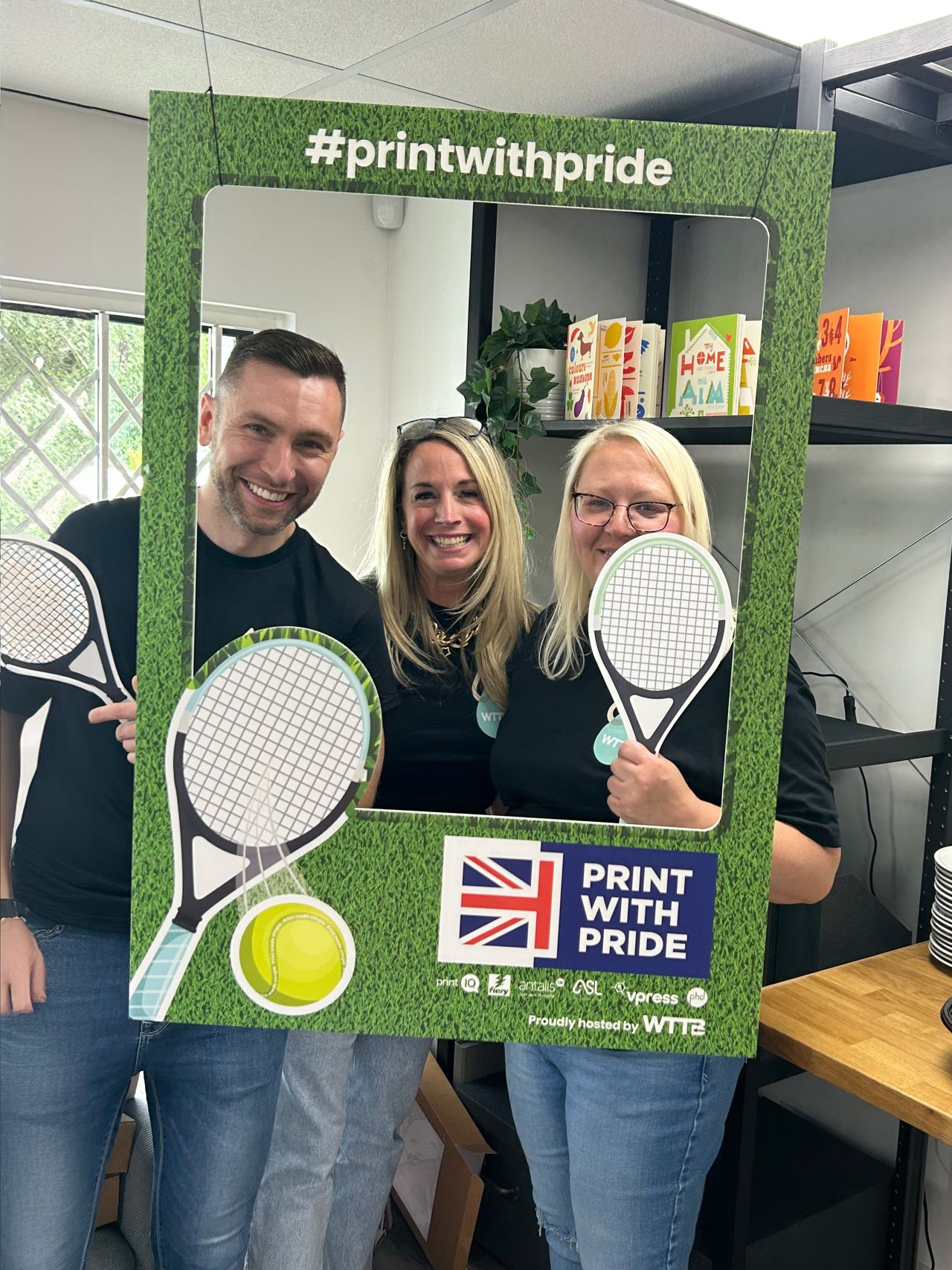 A vibrant photo booth at a tennis event celebrating pride, featuring colourful decorations and enthusiastic participants.