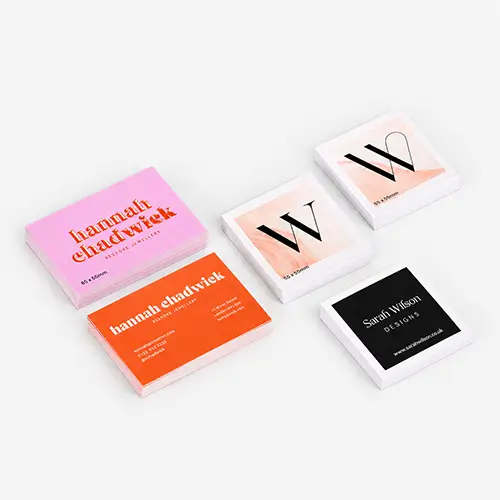 Stacks of colourful business cards arranged on a light gray surface with spot UV.