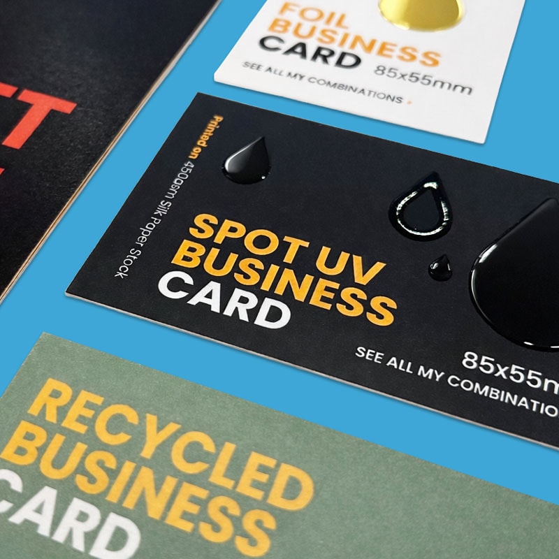 Three different business cards display finishes: foil, spot UV, and recycled on blue background.