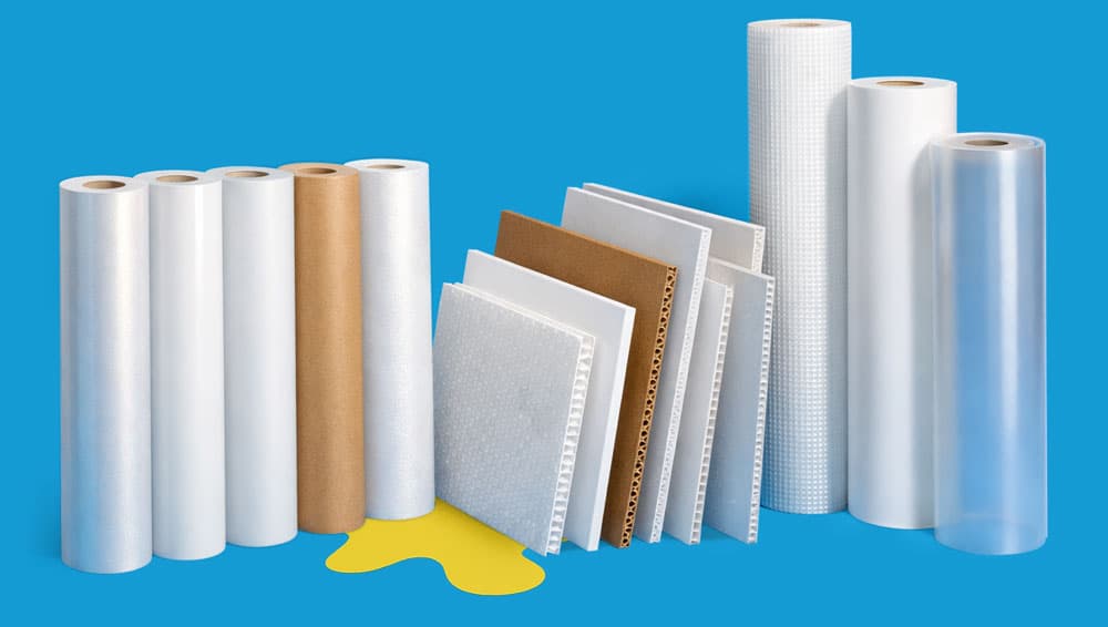 Several rolls of packaging film and samples of packing materials displayed on a blue background.