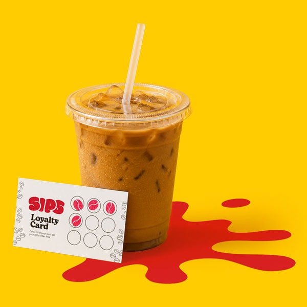 Iced coffee in a plastic cup with a straw and a Sips loyalty card on a yellow background.