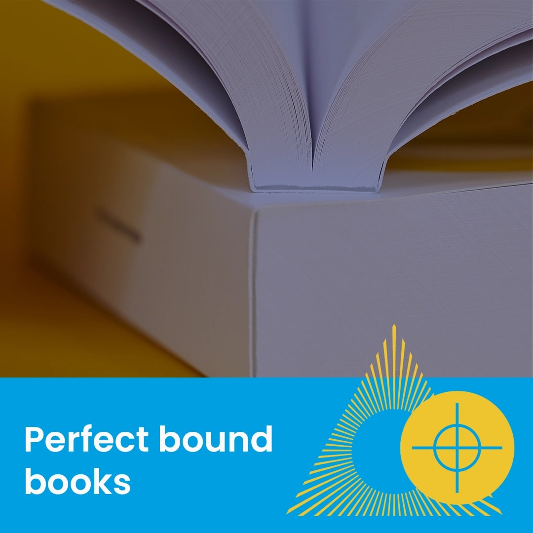 Open perfect bound book with visible spine, blue and yellow graphic design, and text.