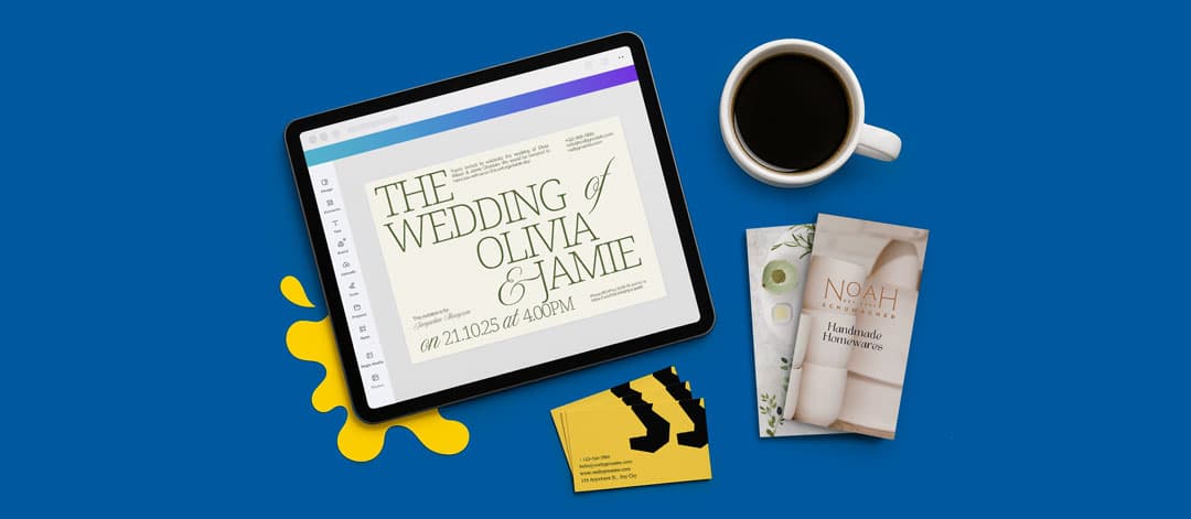 A tablet with a wedding invite, a cup of coffee, brochures, and business cards on a blue surface.