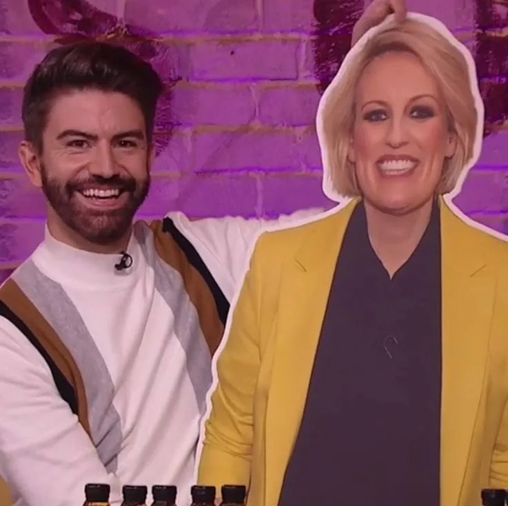 A man standing and holding a cardboard cutout of a woman beside him.