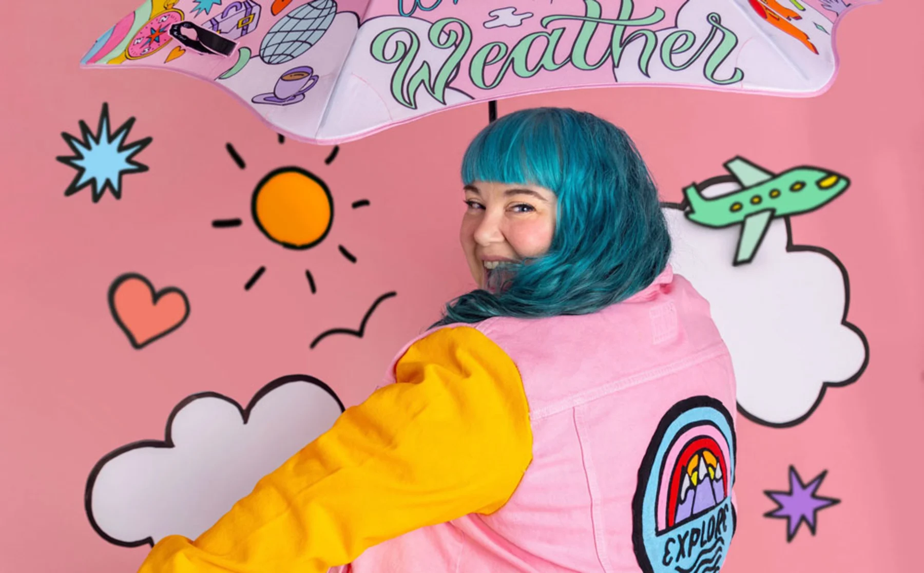 A woman with vibrant blue hair stands under an umbrella, showcasing a unique and colourful style