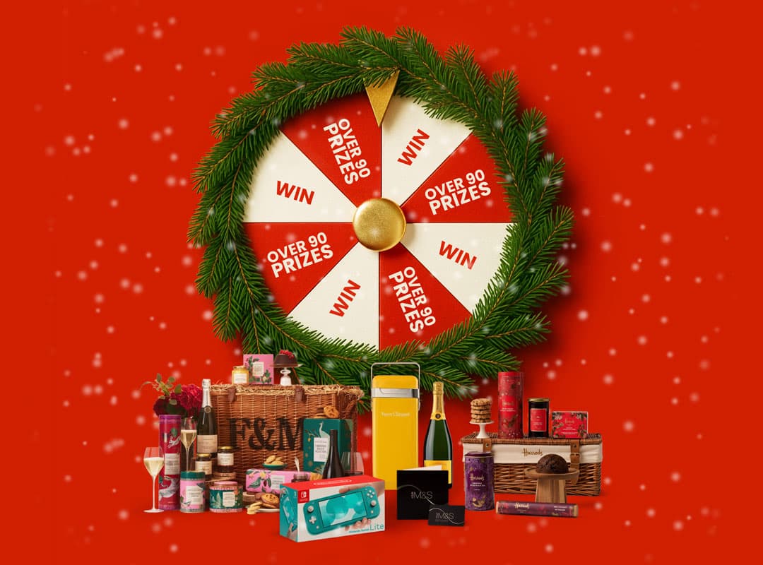 A festive prize wheel with gift hampers, food, and drinks on a red background with snowflakes.