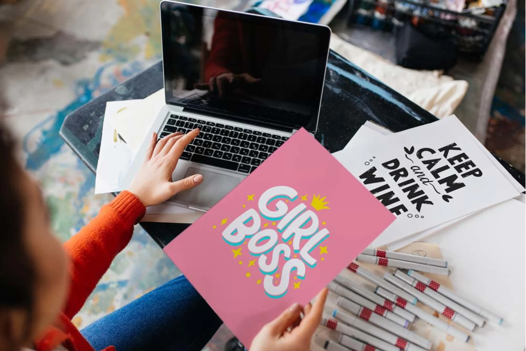 A woman holding a pink flyer with a stylish design and bold "girl boss" lettering in a modern aesthetic
