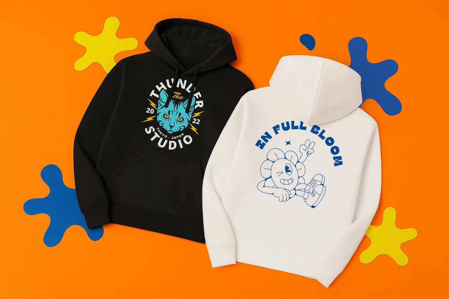 A black and a white hoodie with colourful cartoon graphics on an orange background.