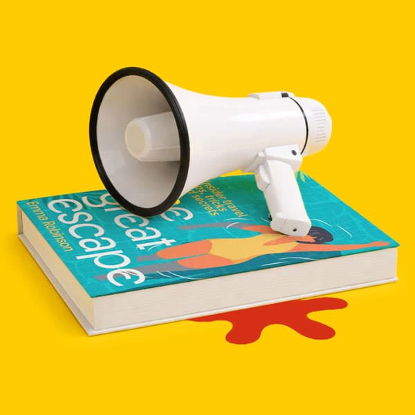 A megaphone on a book titled “The Great Escape” with a red paint splatter underneath.