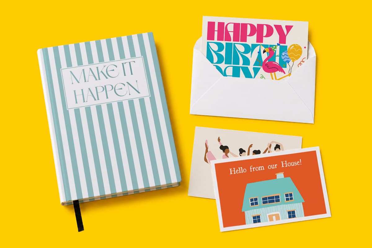 A striped notebook, two greeting cards, and an envelope on a yellow background.