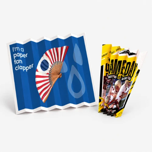 Two folded paper fan clappers, one blue with a fan graphic and one yellow with football imagery.