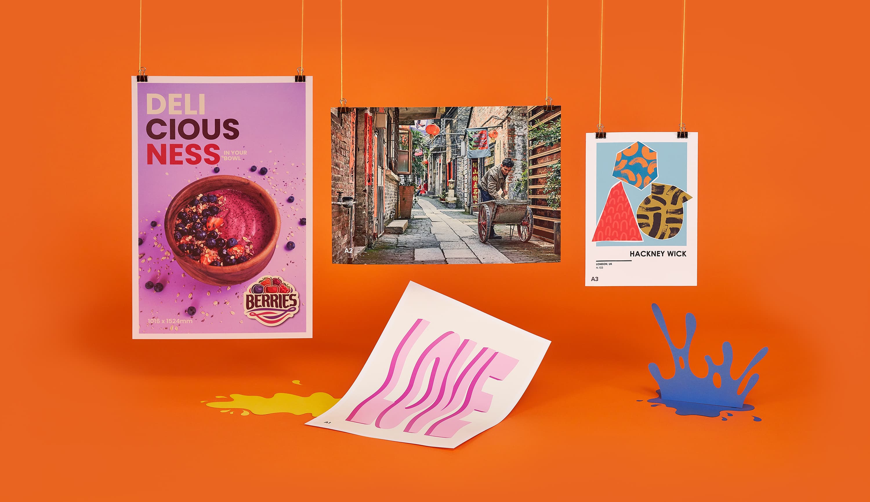 Various colorful posters and prints hanging and on an orange background.