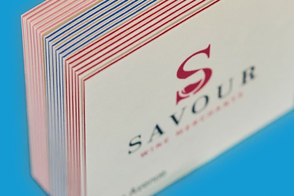 Stack of white business cards with coloured edges and "Savour" printed on the top card.