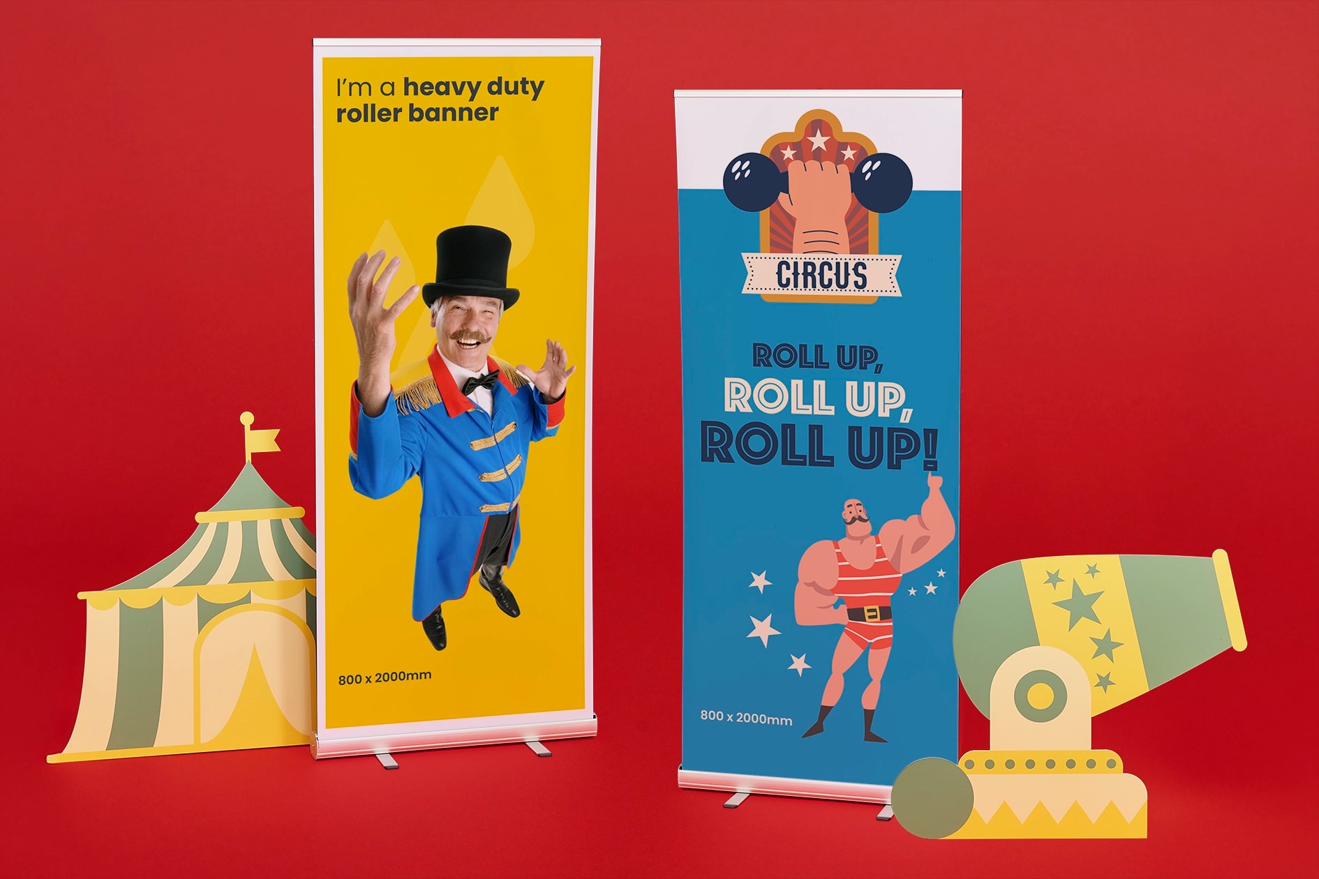 Two colourful circus-themed roller banners stand next to cutouts of a tent and a cannon.