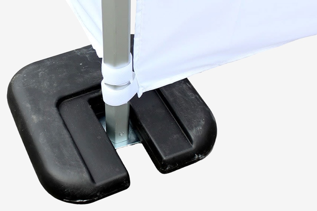 Close-up of a metal pole secured by a white strap and a black weighted base.