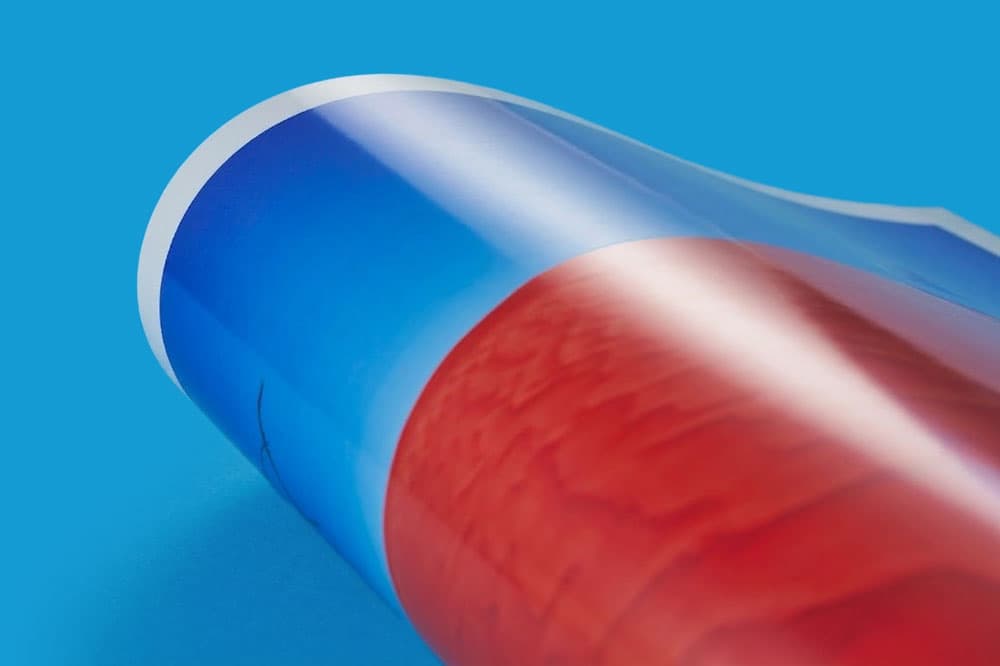 A rolled-up glossy poster with blue and red colors on a blue background.