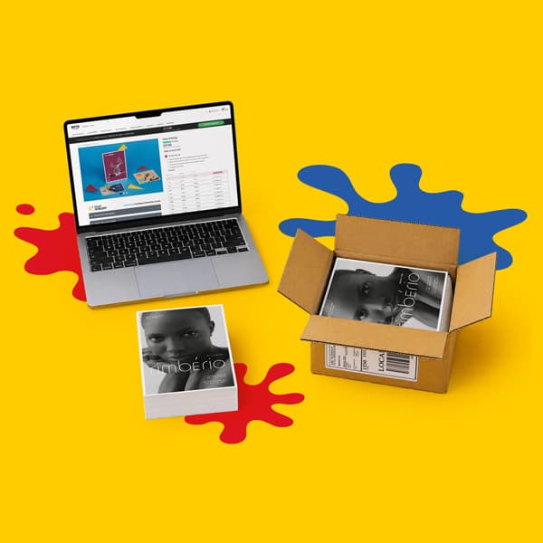 Laptop, books, and open shipping box on yellow background with red and blue paint splashes.