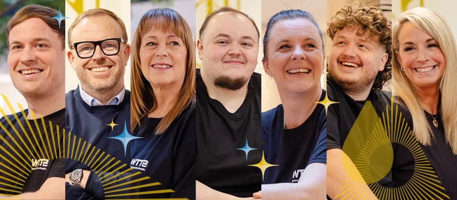 Group of seven people smiling, each wearing branded shirts.